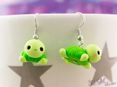 the little turtle earrings are green with black eyes and one is laying on its back