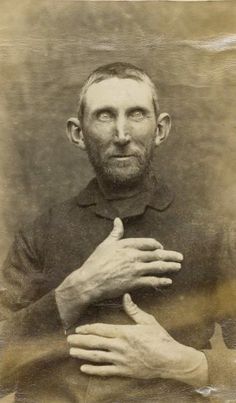 an old black and white photo of a man holding his hands