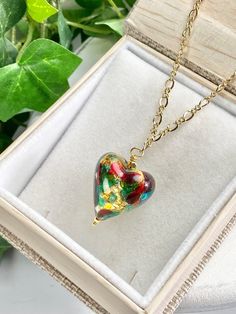 "Sweet, Heart pendant necklace of genuine Murano glass from the artisans in Murano, Italy! You will love this pretty glass pendant that is full of color and whimsy. Show her that you love her with this heart of multi colors swirling and dancing. The glass has 14k gold foil within them to add to the sparkle of colors of gold, red and green ! The gorgeous chain is Gold Fill with lobster claw clasp. The glass heart bead is about 3/4 of an inch and then the drop of the total pendant is about 1.25 in Green Heart Beads Necklace For Gift, Green Heart Necklace For Gift, Glass Pendant Necklaces For Gifts, Green Heart Beads Necklace As Gift, Green Heart Beads Necklace For Gifts, Green Necklaces With Heart Beads For Gifts, Elegant Multicolor Heart Necklace For Gift, Green Heart Necklace For Valentine's Day Gift, Glass Pendant Necklace For Gifts