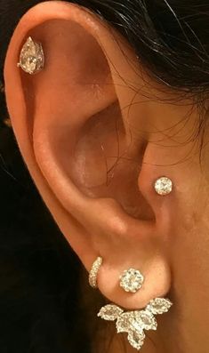 an ear with three different types of piercings on it