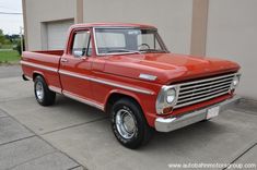 an old red truck parked in front of a building