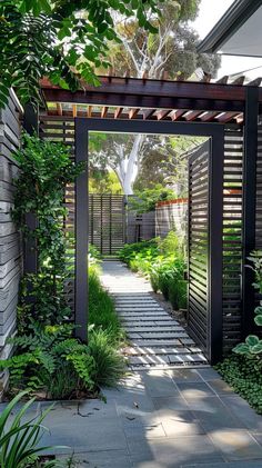 an outdoor garden with lots of greenery and plants on the side of the building