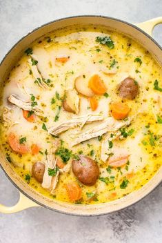 a pot filled with chicken, potatoes and carrots