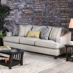 a living room filled with furniture and a brick wall in the back drop off area