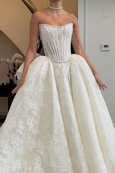 a woman in a white wedding dress standing next to a stair case with her hands on her hips