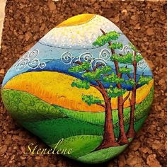 a painted rock with trees on it