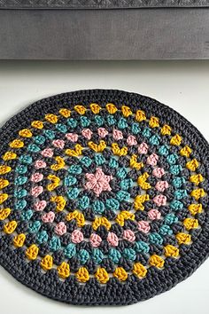 a crocheted round rug on top of a table