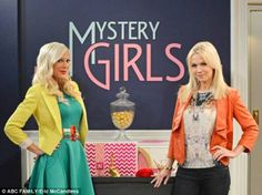 two women standing next to each other in front of a sign that says mystery girls