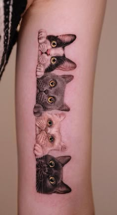 a woman's arm with four cats on it