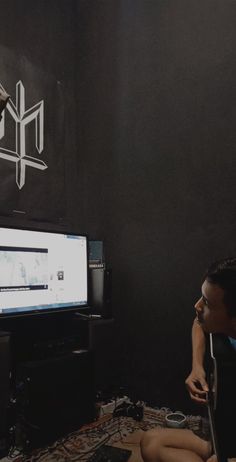 a man sitting on the floor in front of a flat screen tv next to a woman