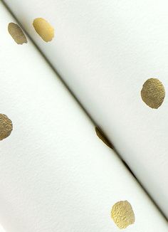 gold polka dots on white paper