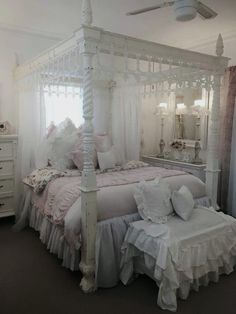 a white canopy bed sitting in a bedroom next to a dresser and mirror on top of a carpeted floor