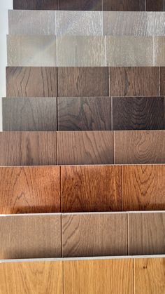 different types of wood flooring samples in various colors and sizes, arranged on top of each other