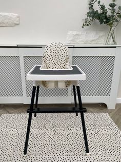 a black and white baby highchair with polka dot fabric on the seat cover