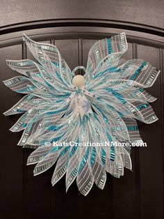 a blue and white wreath hanging on the front door of a house with an ornate design