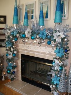 a fireplace decorated for christmas with blue and silver decorations