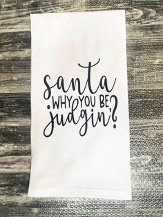 a white tea towel with the words santa, why you be juggin? on it