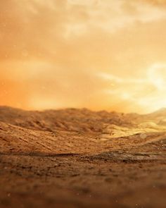 a red fire hydrant sitting in the middle of a dirt field under a cloudy sky