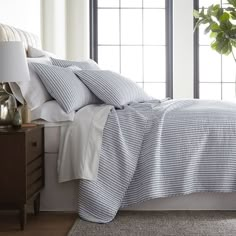 a bed with blue and white striped sheets