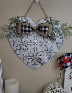 a heart hanging on the wall with two bow ties attached to it's sides