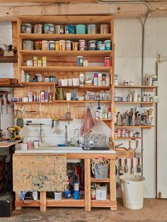 a workbench with lots of crafting supplies and tools on the shelves above it