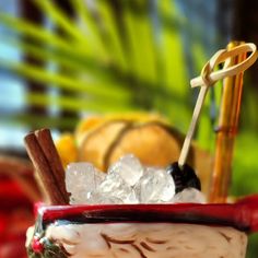 a bowl filled with ice, cinnamon sticks and some fruit on top of a table