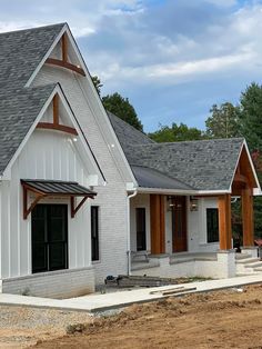 a white house with wood trim on the roof