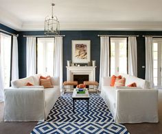 a living room with blue walls and white furniture