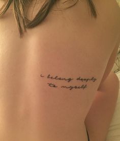 a woman with a tattoo saying i belong deeply to yourself on her upper back shoulder