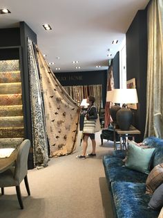 a woman is standing in the middle of a room that has curtains hanging from it