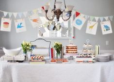 a table topped with cake and desserts under a window next to a chandelier