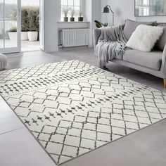 a living room with a gray couch and white rug