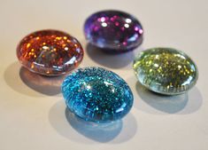 four different colored stones sitting on top of a table