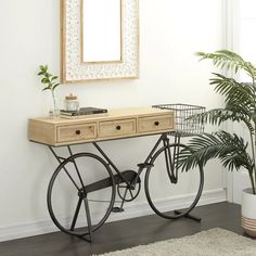 a wooden table sitting next to a potted plant on top of a hard wood floor