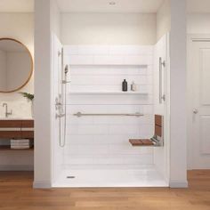 a white bathroom with wood flooring and large mirror on the wall above the shower