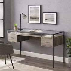 an office desk with two framed pictures on the wall