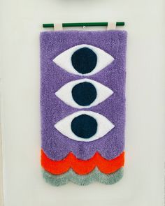 a purple towel with two eyes hanging from it