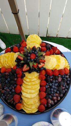 a platter filled with fruit on top of a blue table cloth