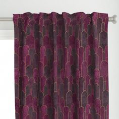 a purple curtain with an art deco design on the top and bottom, hanging in front of a window