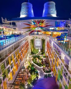 the top deck of a cruise ship at night with colorful lights and plants on it