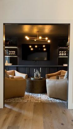 a living room filled with furniture and a flat screen tv mounted to the wall over a fireplace