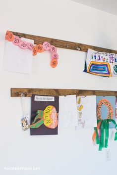 two wooden pegs are hanging on the wall with pictures and magnets attached to them