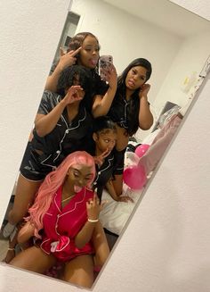 four women in black and pink outfits posing for the camera