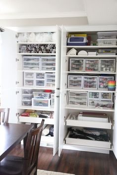 an organized pantry with plastic bins and drawers