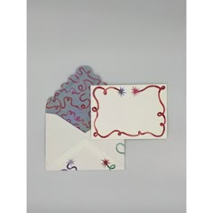 three envelopes with red and blue designs on white paper, one has a blank card in the middle