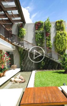 an outdoor area with wooden benches and plants on the wall, grass in the foreground