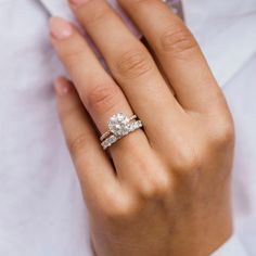 a woman's hand with two engagement rings on it