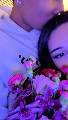 a woman laying next to a man with flowers