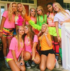 a group of young women standing next to each other in front of a house wearing neon colored outfits