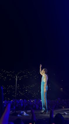 a man standing on top of a stage in front of a crowd at a concert